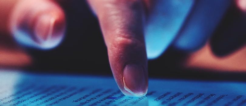 Extreme close up of female finger using digital tablet computer Extreme close up of female finger using digital tablet computer at home in the evening to read the news online, selective focus