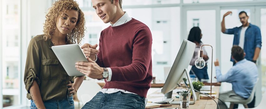 Creating a cool marketing campaign with one smart app Shot of two young colleagues using a digital tablet together in a modern office